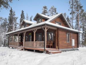 una cabaña de madera en la nieve en el bosque en Holiday Home Kiehtäjän virta by Interhome, en Käylä