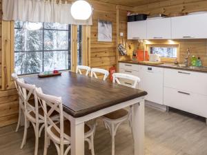 eine Küche mit einem Holztisch und weißen Schränken in der Unterkunft Holiday Home Kiehtäjän virta by Interhome in Käylä