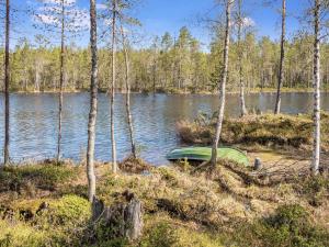 ein grünes Boot am Ufer eines Sees in der Unterkunft Holiday Home Kiehtäjän virta by Interhome in Käylä