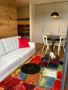 a living room with a white couch and a table at Apartmán Brčálník Šumavské Stráně in Hojsova Stráž