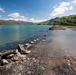 a large body of water with rocks on the shore at Wavecrest in Barmouth +37 photos