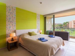 a bedroom with a bed with two blue towels on it at Apartment Salgados Beach & Golf by Interhome in Galé
