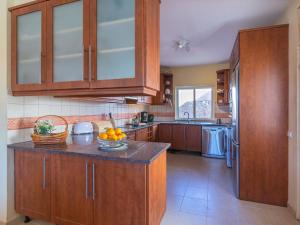 een keuken met houten kasten en een kom sinaasappels op het aanrecht bij Villa Villa Rosa by Interhome in Loulé