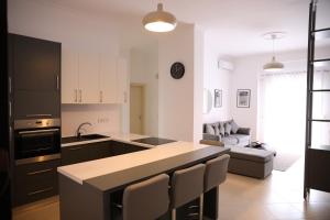 a kitchen with a counter top and a living room at Square View Apartment in Vlorë