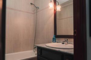 Un baño con lavabo, espejo y bañera. en Casa Pepita Feria, en Valverde del Camino 31 fotos más