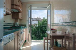 una cocina con mesa y una gran puerta de cristal en Casa Pepita Feria, en Valverde del Camino
