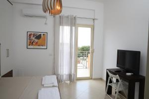 a bedroom with a bed and a tv and a window at Square View Apartment in Vlorë