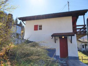 a small house with a red door on a hill at Holiday Home Cà Listra by Interhome in Gudo