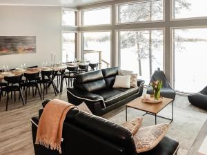 KarjalaisenniemiにあるHoliday Home Villa kallas by Interhomeのリビングルーム(黒革の家具、テーブル付)