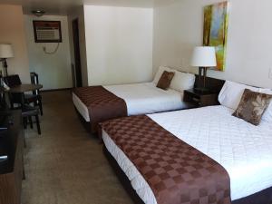 Habitación de hotel con 2 camas y escritorio en Lakeshore Motel Ice Lake, en Iron River