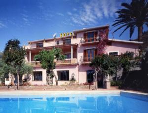 a house with a swimming pool in front of a building at Hotel Villa Sirina in Taormina