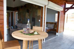 una bottiglia di alcol appoggiata su un tavolo di legno in una stanza di KARUKERA - Les Villas KIKKO a Sèze
