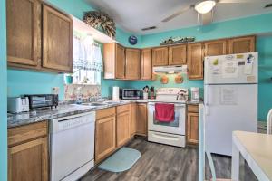 a kitchen with wooden cabinets and white appliances at Chincoteague Townhome with Pony Views from Deck! in Chincoteague