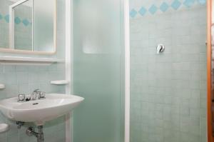 uma casa de banho com um lavatório e um chuveiro em Hotel Rugantino em Cesenatico