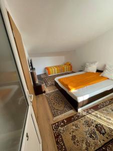 Habitación pequeña con cama y alfombras en Casa Wiesmann Băile Felix, en Băile Felix