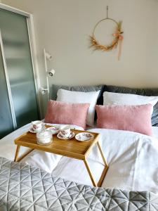 a coffee table on a bed with pink pillows at 2ndhomes Unique and Luxury Kamppi Center Apartment with Sauna and Big Terrace in Helsinki