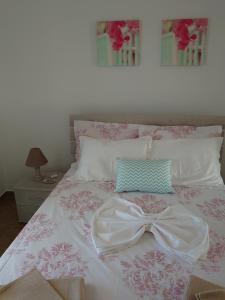 a bed with a white dress and a bow on it at Annezina's memories in Logaras