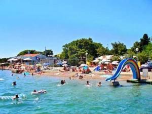 a group of people in the water at a beach at Apartment Perkovic Jadranka in Kornić
