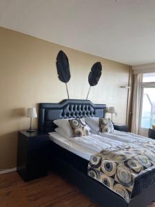 a bedroom with a large bed with a black headboard at Studio Coastview in Zandvoort