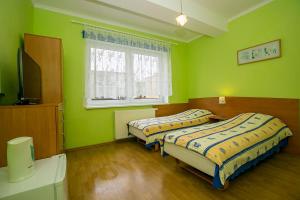two beds in a room with green walls at Willa Anna in Międzyzdroje