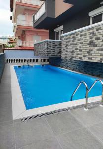 a swimming pool with blue water in front of a building at Princess Luxury Suite 2 in Paralia Katerinis