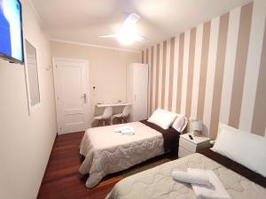 a small bedroom with two beds and a desk at Pensión Atenea Pilgrims in Caldas de Reis