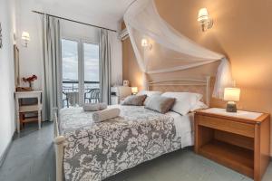 um quarto com uma cama, uma mesa e uma janela em Eros Beach Hotel em Benitses
