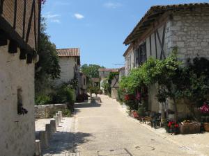 an alley in a village with flowers and buildings at Bordo Basso in Laugnac