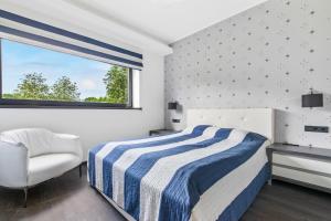 a bedroom with a bed and a chair and a window at Sadama 4 Apartment in Pärnu