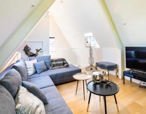 un soggiorno con divano blu e TV di Antwerp old town triplex apartment ad Anversa