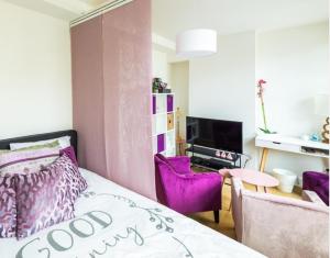 a bedroom with a bed and purple chairs at Antwerp old town appartment in Antwerp