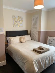a bedroom with a bed with a towel on it at Twin Palms Guesthouse in Great Yarmouth