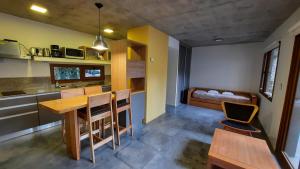 uma cozinha com uma mesa e cadeiras e uma cama em Apartamento Álamos de los Andes PB em San Martín de los Andes