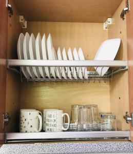 ein Regal voller Teller und Tassen in einer Küche in der Unterkunft Comfy classic apartment in Trakai in Trakai