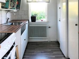 eine Küche mit weißen Arbeitsflächen, einem Waschbecken und einem Fenster in der Unterkunft Holiday home KÅRBÖLE in Kårböle