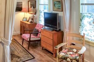 ein Wohnzimmer mit einem TV auf einer Holzkommode in der Unterkunft Rustic-Chic Cottage with Yard and Grill - Near Hiking! in Northfield