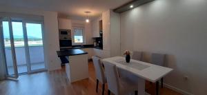 a kitchen with a white table and chairs in a room at Apartman Ana - Posušje in Posušje