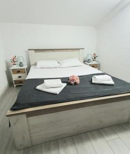 a large bed with two towels and flowers on it at Apartman Anja in Budva