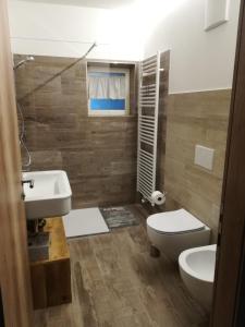 a bathroom with a toilet and a sink at CASA RAINA in Castelfondo +15 photos
