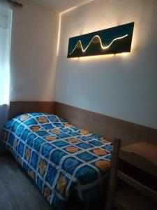 a bedroom with a bed and a light on the wall at CASA RAINA in Castelfondo