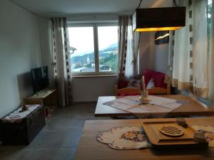a living room with a table and a large window at CASA RAINA in Castelfondo