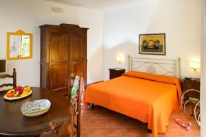 a bedroom with a bed, table, chairs and a lamp at Residence Degli Agrumi in Taormina