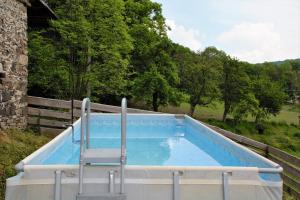 a swimming pool with a chair sitting in it at Na koňské farmě in Malečov