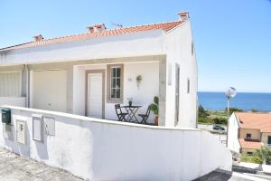 ein weißes Haus mit dem Ozean im Hintergrund in der Unterkunft Casa da Praia in Vila Praia de Âncora