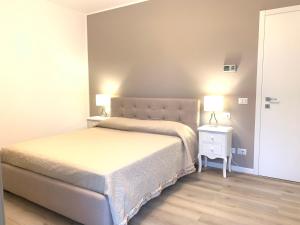 a bedroom with two beds and a night stand with two lamps at Appartamento Internazionale 2 in Abano Terme