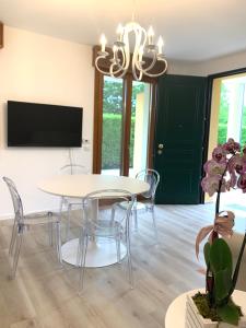 a dining room with a table and chairs and a tv at Appartamento Internazionale 2 in Abano Terme