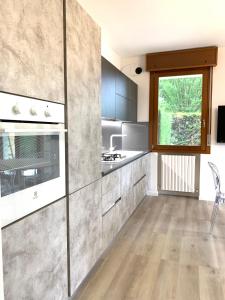 una cocina con electrodomésticos de acero inoxidable y una ventana en Appartamento Internazionale 2, en Abano Terme