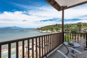 a balcony with a table and chairs and the ocean at Kalokerino in Olympiada