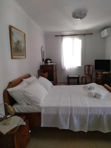 a bedroom with a bed with white sheets and a window at Nostalgia Apartment A in Sami 50 metres from the sea in Sami