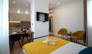 a bedroom with a yellow bed and a kitchen at Apartments Dalmatino in Kaštela
